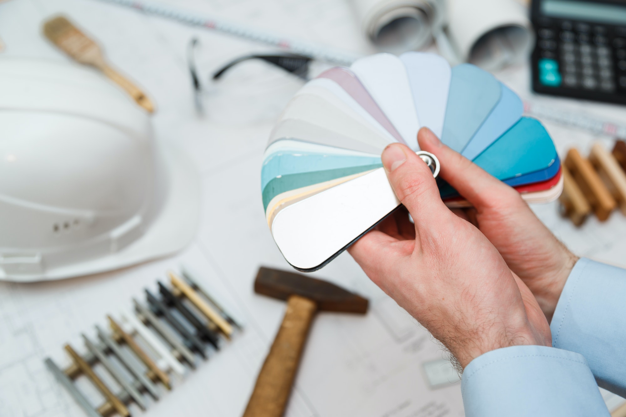 Architect interior's hands drawing home illustration with material sample, renovation concept.